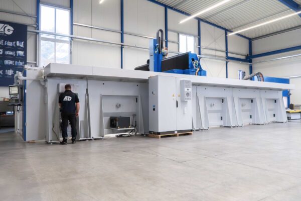 Außenansicht der XXL-CNC-Gantry-Anlage G-S-F/M von HG GRIMME SysTech mit Mitarbeiter als Größenvergleich